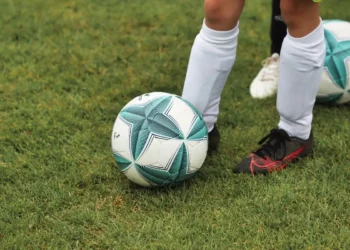 Pallone bianco e verde sul prato accanto ai piedi di un giocatore, foto illustrativa del Trofeo Nuccio Cappadona