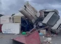 Camion ribaltato e cassonetti rovesciati su un piazzale dopo la tromba marina a Marsala, tra rifiuti e lamiere sparsi a terra