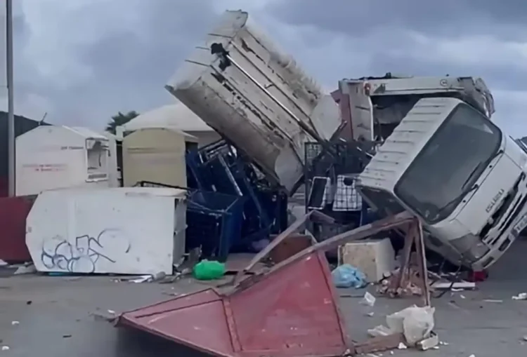 Camion ribaltato e cassonetti rovesciati su un piazzale dopo la tromba marina a Marsala, tra rifiuti e lamiere sparsi a terra