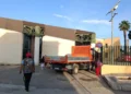 Camion di un’impresa davanti all’ingresso di una scuola a Vittoria, mentre alunni e un adulto arrivano a piedi