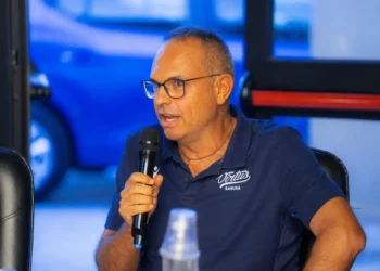 Il coach della Virtus Ragusa Gianni Recupido parla al microfono con polo blu e occhiali, alla vigilia della trasferta a Catanzaro