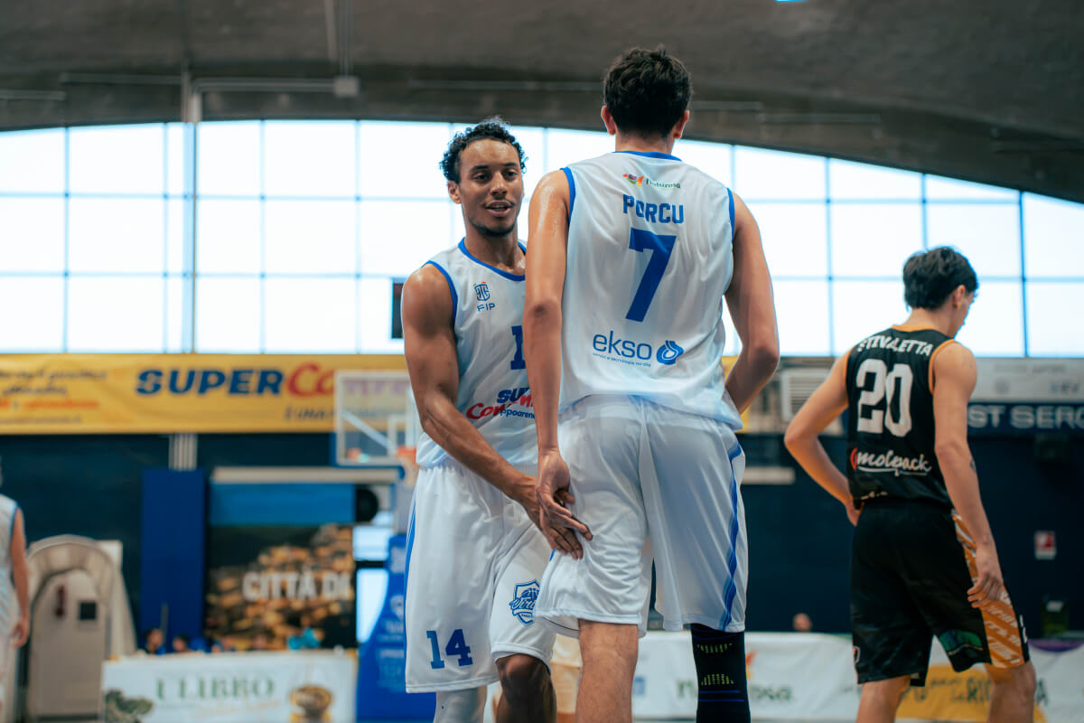 Due giocatori della Virtus Ragusa in maglia bianca si danno la mano in campo, sullo sfondo un avversario di Termoli in maglia nera