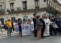 Corteo dell'Anmil Ragusa per le vittime del lavoro, con striscioni, un sindaco con fascia tricolore, un sacerdote e carabinieri