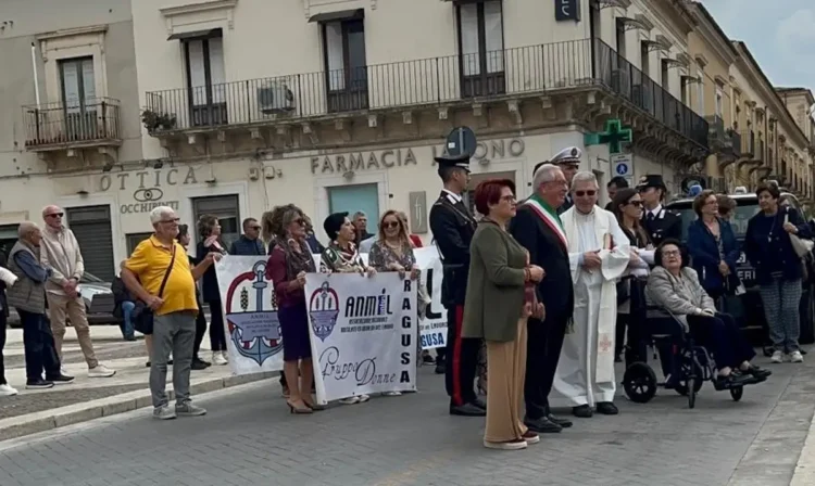Corteo dell'Anmil Ragusa per le vittime del lavoro, con striscioni, un sindaco con fascia tricolore, un sacerdote e carabinieri