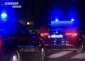Due auto dei carabinieri con i lampeggianti blu accesi, ferme di notte vicino a un attraversamento pedonale