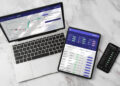 Laptop, tablet e smartphone su un piano di marmo mostrano grafici e quotazioni