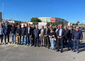 Cantiere nella zona artigianale di Ragusa: mini escavatore, recinzioni arancioni e segnale di divieto su una strada asfaltata